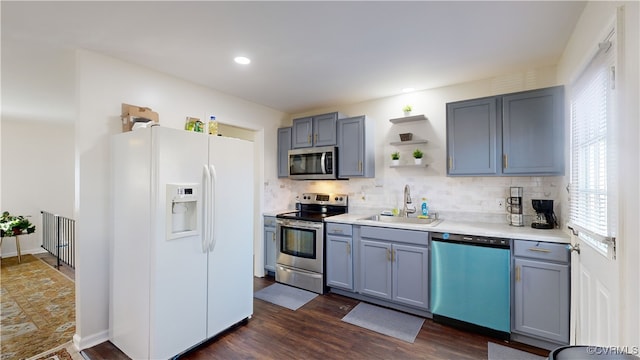 kitchen with stainless steel appliances, sink, dark hardwood / wood-style floors, and decorative backsplash