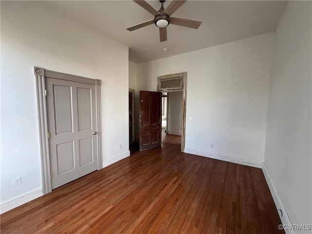 unfurnished bedroom with ceiling fan and dark wood-type flooring