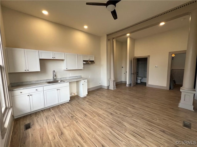 kitchen featuring white cabinets, light hardwood / wood-style floors, ceiling fan, and sink