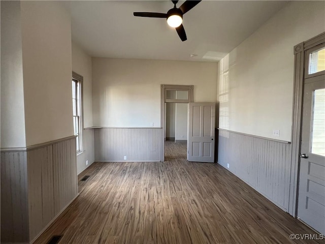 spare room with dark hardwood / wood-style floors, plenty of natural light, and ceiling fan