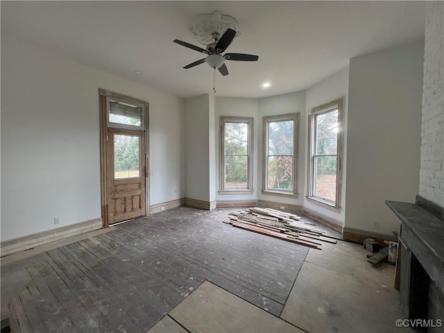 unfurnished living room with ceiling fan