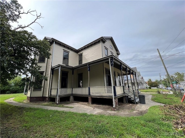 view of side of home featuring a yard and a porch