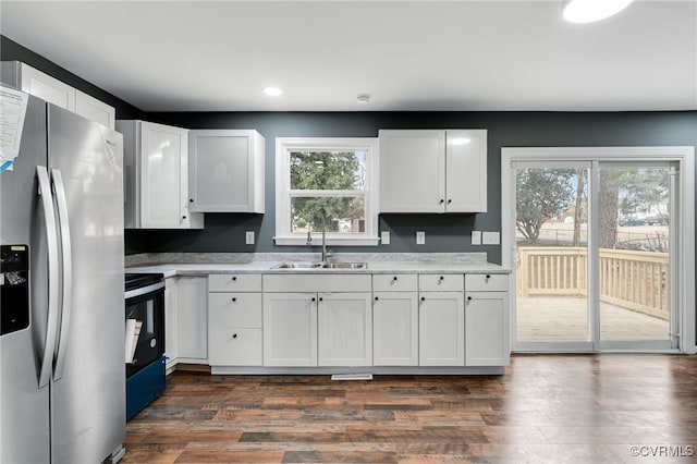 kitchen with plenty of natural light, sink, white cabinetry, and stainless steel refrigerator with ice dispenser