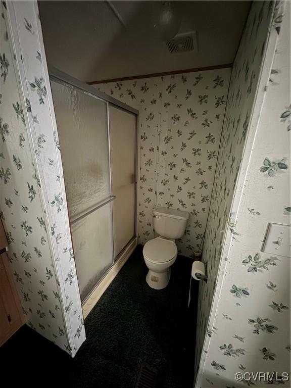 bathroom with toilet and walk in shower