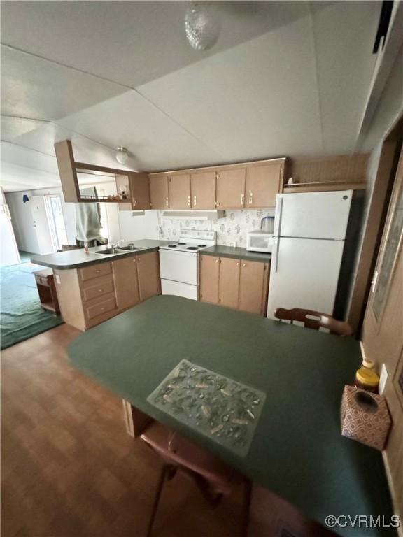 kitchen featuring kitchen peninsula, light brown cabinets, white appliances, and sink