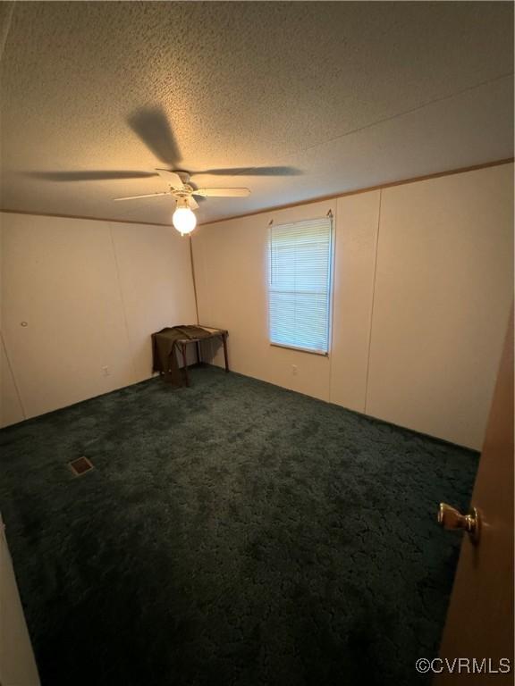 unfurnished room featuring ceiling fan, carpet floors, and a textured ceiling