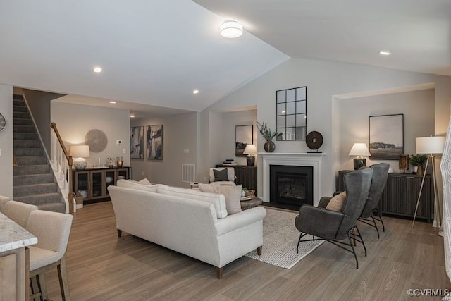 living room with lofted ceiling and light hardwood / wood-style flooring