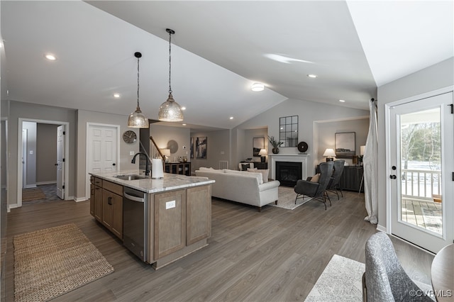 kitchen featuring dishwasher, sink, hanging light fixtures, hardwood / wood-style floors, and an island with sink