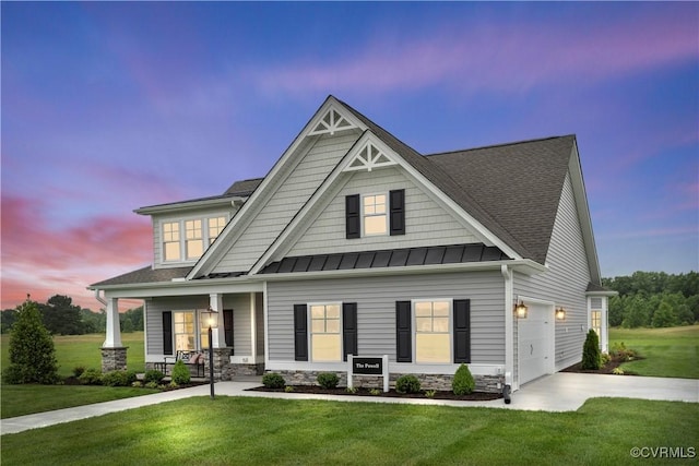 craftsman inspired home with a lawn, a porch, and a garage