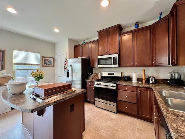 kitchen featuring a breakfast bar, appliances with stainless steel finishes, a center island, and sink