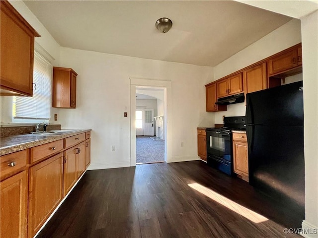 kitchen with sink, dark wood-type flooring, a healthy amount of sunlight, and black appliances