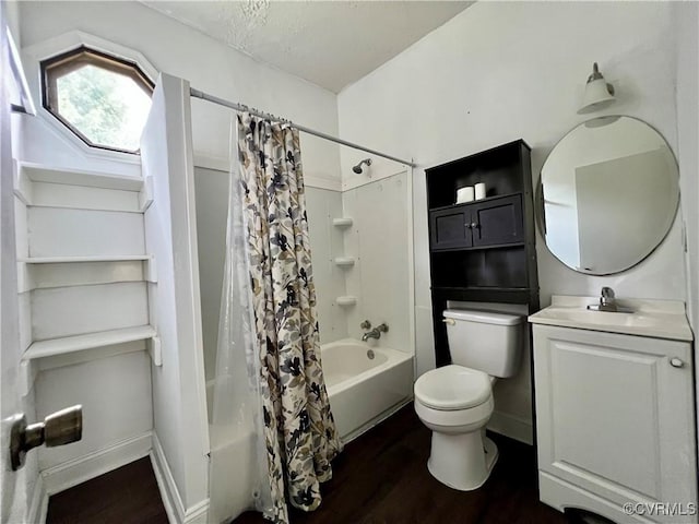 full bathroom with vanity, hardwood / wood-style flooring, toilet, shower / bath combo with shower curtain, and a textured ceiling