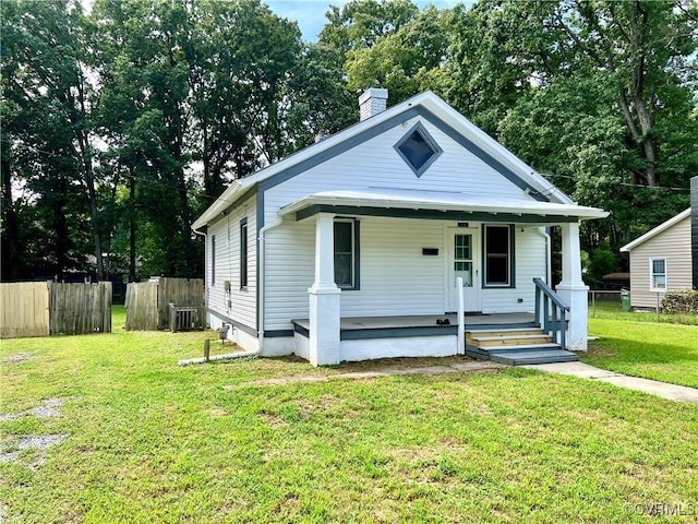 bungalow-style house with a porch, a front lawn, and central air condition unit