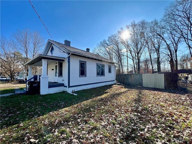 view of property exterior featuring a porch and a lawn