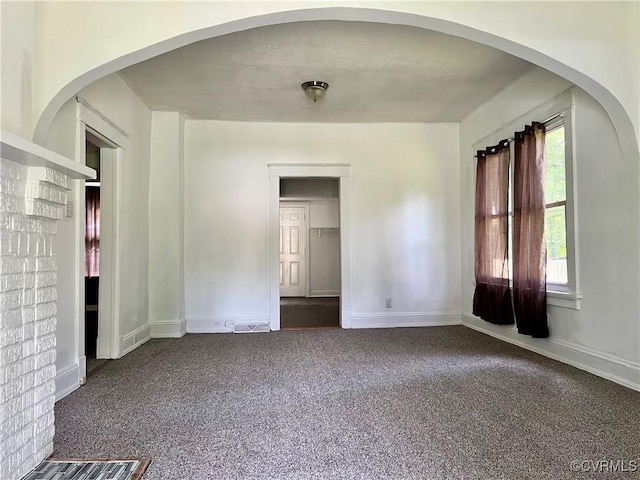 spare room featuring dark colored carpet