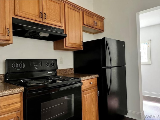 kitchen featuring black appliances and dark stone countertops