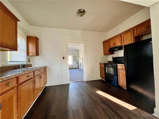 kitchen featuring black appliances, a healthy amount of sunlight, dark hardwood / wood-style flooring, and sink