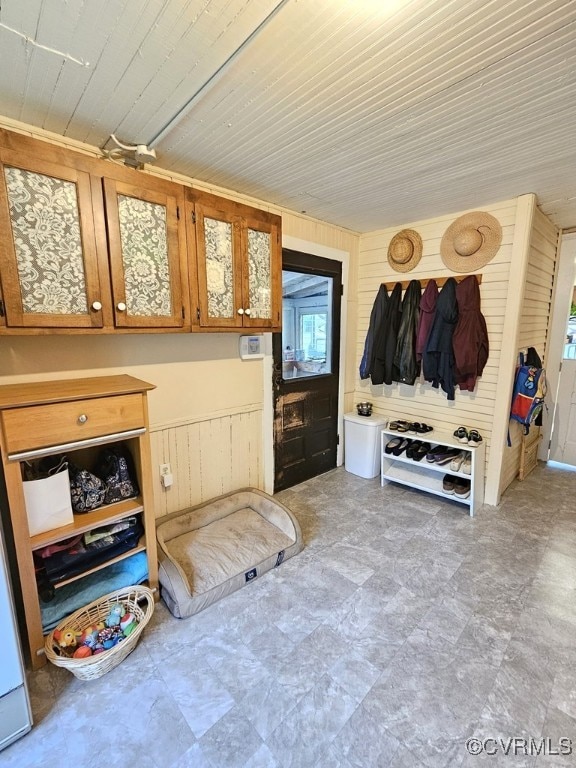mudroom with wood walls and wooden ceiling