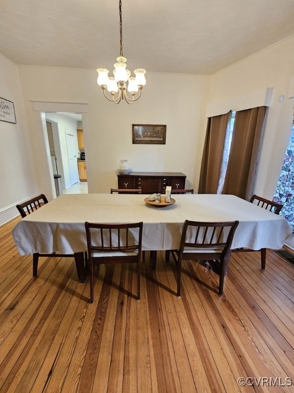 dining room with hardwood / wood-style floors and a notable chandelier