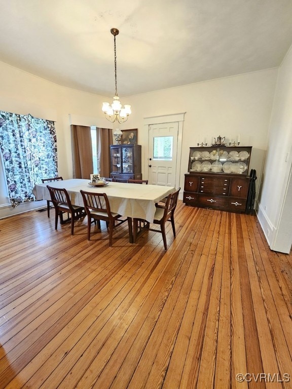 dining space featuring light hardwood / wood-style flooring and an inviting chandelier