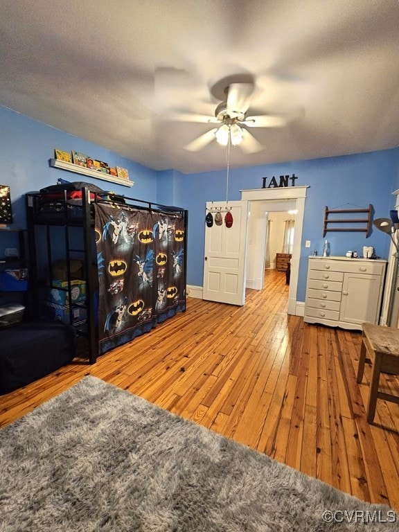 bedroom with baseboards, a ceiling fan, and hardwood / wood-style floors