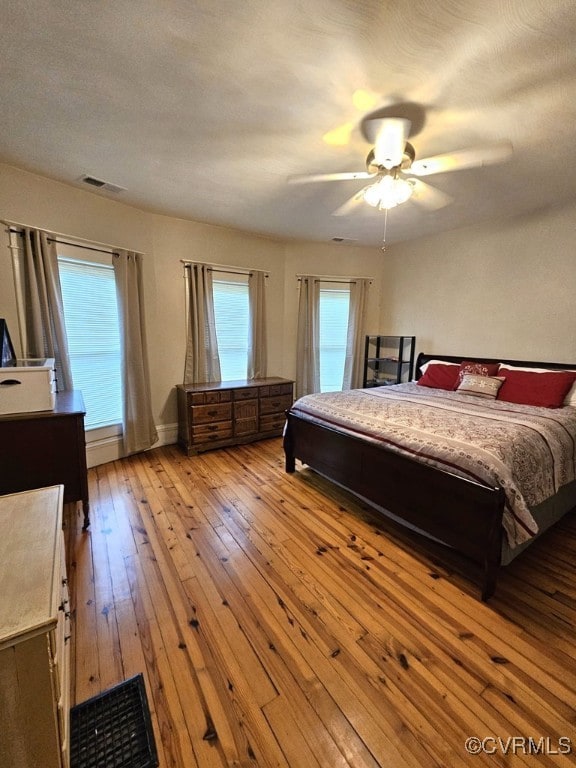 bedroom featuring ceiling fan, a textured ceiling, and light wood-type flooring