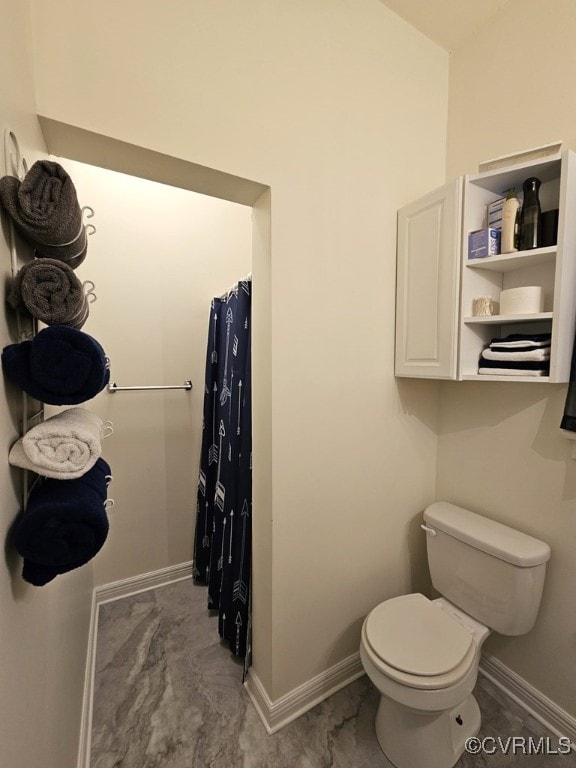 full bath featuring toilet, a shower with shower curtain, and baseboards