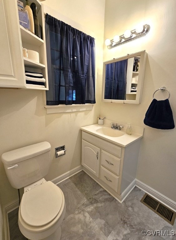 bathroom featuring marble finish floor, visible vents, toilet, and baseboards