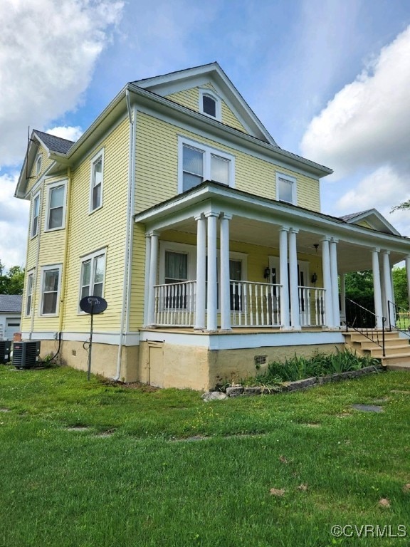 view of side of property with central air condition unit, a yard, and covered porch