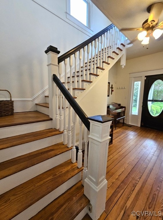 stairs with ceiling fan and hardwood / wood-style floors