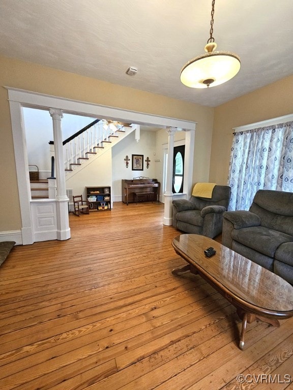 living room featuring light wood-type flooring and ornate columns