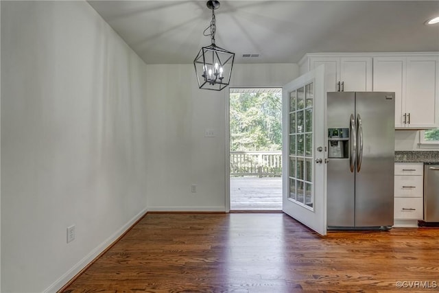 interior space featuring dark wood-type flooring and an inviting chandelier