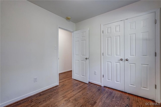 unfurnished bedroom featuring dark hardwood / wood-style flooring and a closet