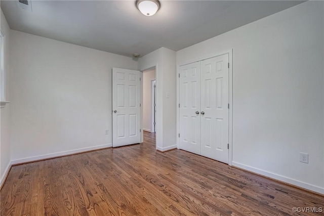 unfurnished bedroom with hardwood / wood-style floors and a closet