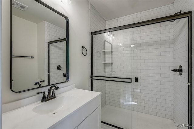 bathroom with vanity and a shower with door