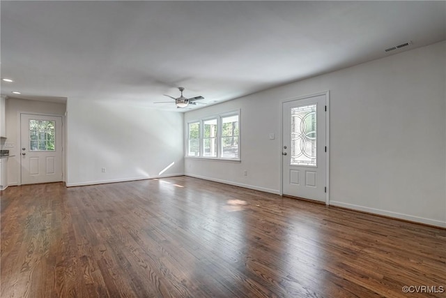 unfurnished living room featuring ceiling fan, plenty of natural light, and dark wood-type flooring