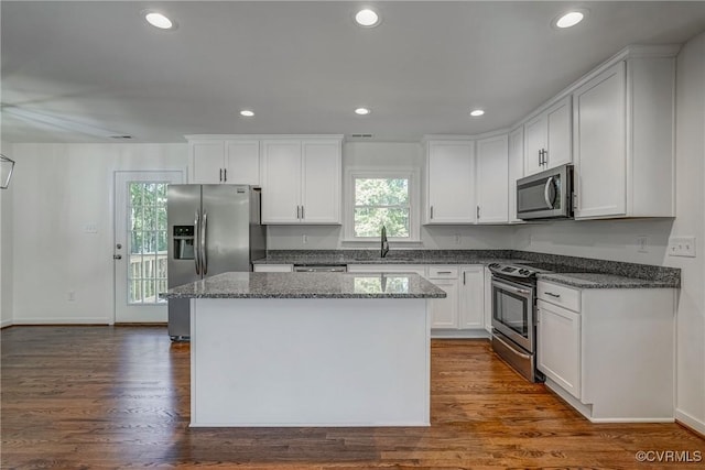 kitchen featuring sink, a kitchen island, dark hardwood / wood-style flooring, white cabinetry, and stainless steel appliances