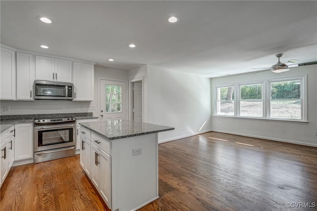 kitchen with a center island, ceiling fan, appliances with stainless steel finishes, dark hardwood / wood-style flooring, and white cabinetry