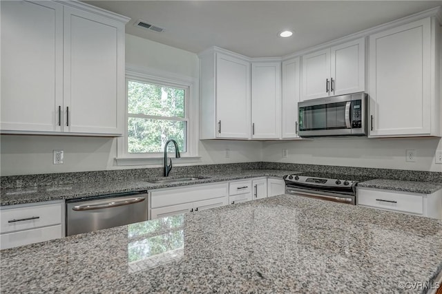 kitchen featuring white cabinets, light stone counters, sink, and stainless steel appliances