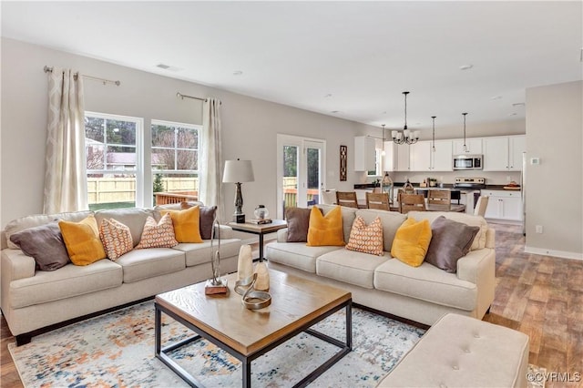 living room featuring light wood-type flooring and an inviting chandelier