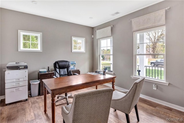 home office with light hardwood / wood-style flooring