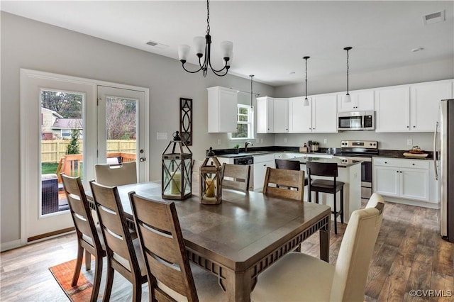 dining room with a chandelier, dark hardwood / wood-style flooring, a wealth of natural light, and sink