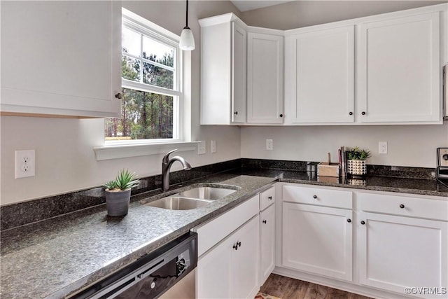 kitchen featuring stainless steel dishwasher, sink, pendant lighting, wood-type flooring, and white cabinets