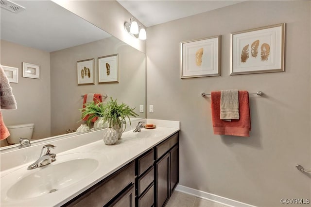 bathroom featuring tile patterned flooring, vanity, and toilet