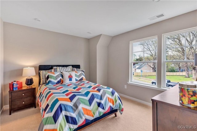 bedroom with light colored carpet and multiple windows