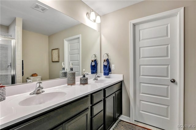 bathroom featuring toilet, vanity, and walk in shower