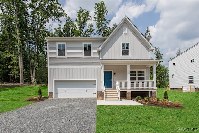 view of front of house featuring covered porch, a garage, and a front lawn