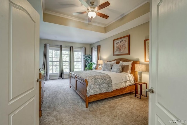 bedroom with a tray ceiling, light carpet, ceiling fan, and ornamental molding