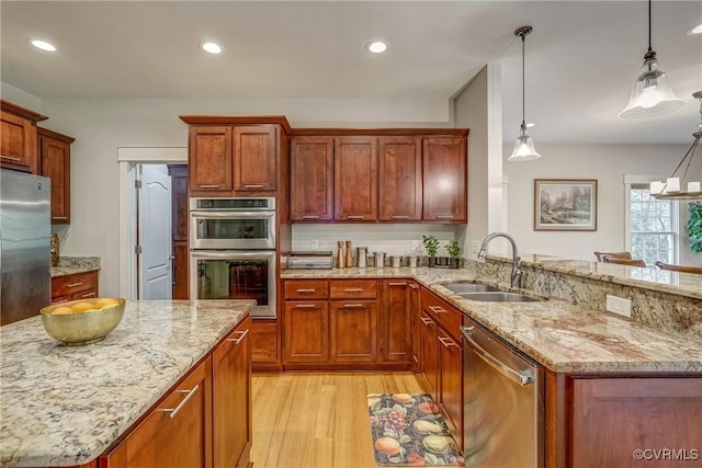 kitchen with appliances with stainless steel finishes, pendant lighting, and sink