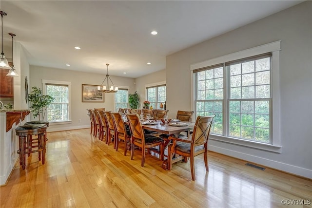 dining space featuring an inviting chandelier and light hardwood / wood-style flooring